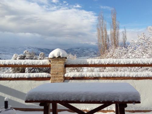 a bench sitting on a fence covered in snow at CASA RURAL "LOS CASARES" in Nerpio