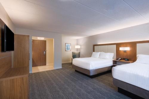 a hotel room with two beds and a flat screen tv at Holiday Inn Express Boston-Waltham by IHG in Waltham