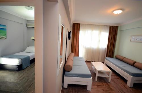 Habitación pequeña con 2 camas y sofá en Two Seas Hotel, en Marmaris