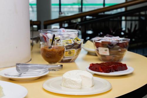 un tavolo con piatti di cibo e ciotole di dessert di Hotel Midas a Cornélio Procópio