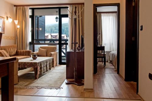 バンスコにあるCozy Suite in 5* Luxury Spa Hotelのリビングルーム(ソファ、テーブル付)
