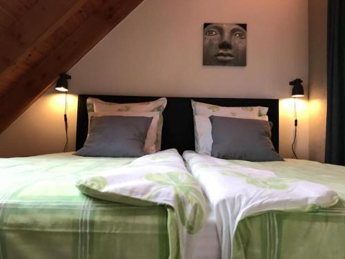 a bedroom with two beds and a headboard with a mask at Gastenverblijf Chambre dAmis in Heers