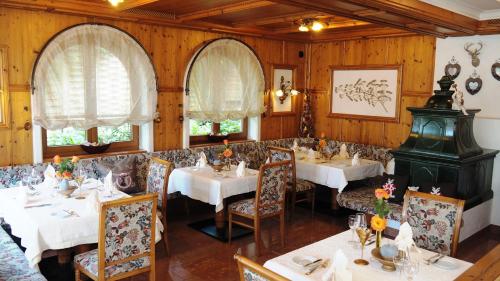 a dining room with white tables and chairs at Hotel Schwarzenbergs Traube in Glottertal
