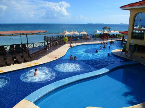a pool at a resort with people in the water at Tropical apartment in Cancún
