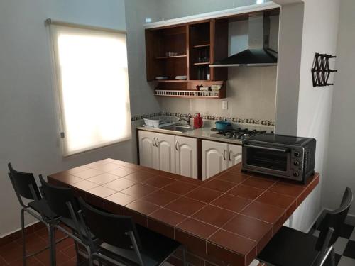 a kitchen with a wooden table with a microwave at Casa Viveros in San Juan Teotihuacán