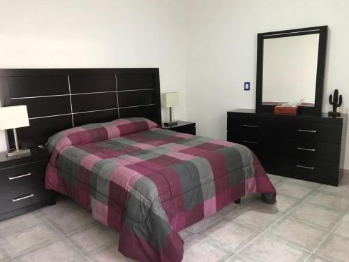 a bedroom with a bed and a dresser and a mirror at Casa Viveros in San Juan Teotihuacán