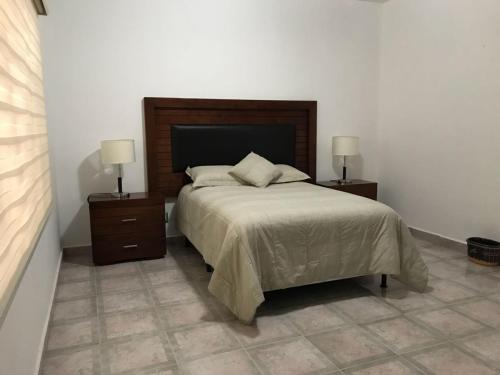 1 dormitorio con 1 cama con 2 mesitas de noche y 2 lámparas en Casa Viveros, en San Juan Teotihuacán