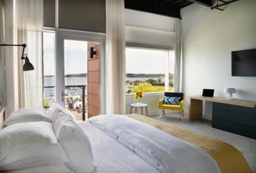 a bedroom with a large white bed with a large window at 250 Main Hotel in Rockland