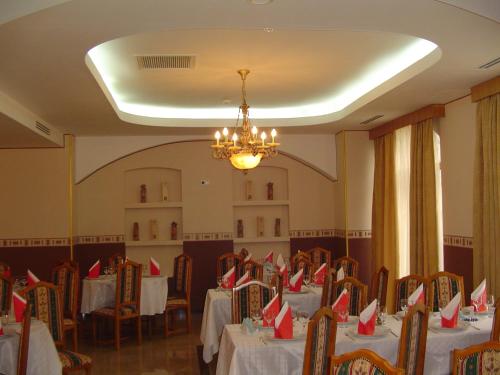un comedor con mesas y sillas con servilletas rojas. en Hotel Europa, en Ploieşti