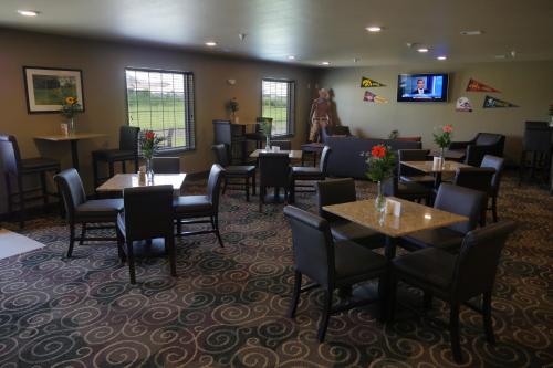 a restaurant with tables and chairs and a woman standing in the background at Cobblestone Inn & Suites-Winterset in Winterset