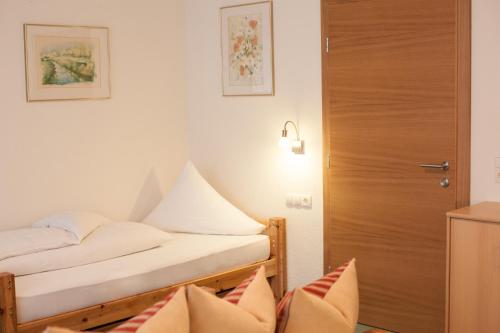 a bedroom with a bed and a wooden door at Apart Alpenblick in Pfunds