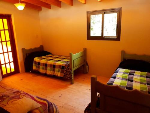 1 dormitorio con 2 camas y ventana en Mágico Atardecer Cabaña en Tunuyán