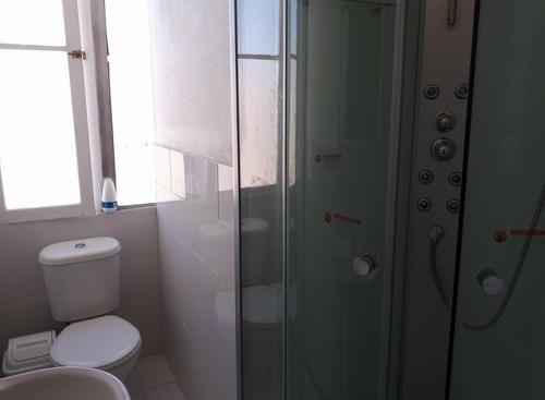 a bathroom with a toilet and a glass shower at Hospederia Taltal in Taltal