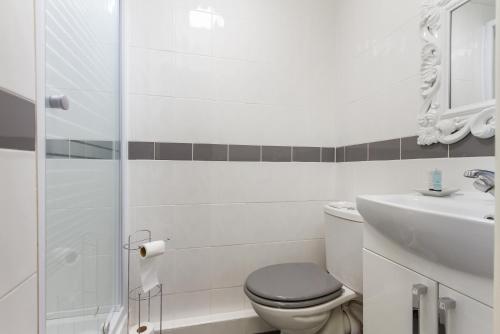 a white bathroom with a toilet and a sink at Adelaide Lodge - Town Centre - Opposite Winter Gardens in Blackpool
