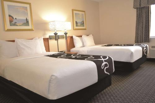 a hotel room with two beds with white sheets at La Quinta by Wyndham Tampa Fairgrounds - Casino in Tampa