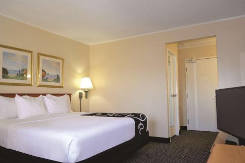 a hotel room with a bed and a flat screen tv at La Quinta by Wyndham Tampa Fairgrounds - Casino in Tampa