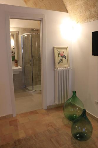two green glass vases sitting on the floor in a bathroom at Casa Ela in Matera