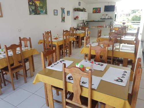 a dining room with wooden tables and chairs at Pousada Privê Maré Alta in Porto De Galinhas