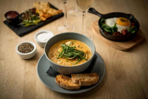 een tafel met een kom soep en een bord brood bij French Horn Chalets in Alton