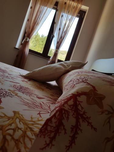 a bedroom with a bed with pillows and a window at Zefiro Casa Vacanze in Ascea
