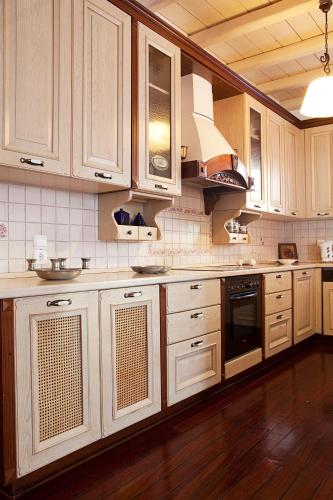 a kitchen with white cabinets and a sink at Arte & Mare Elia Luxury Suites and Villas in Elia Beach