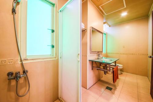 baño con ducha, lavabo y ventana en 悅庭民宿 en Zhixue