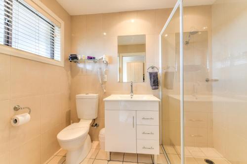 a bathroom with a toilet and a shower and a sink at Motel Grande in Tamworth