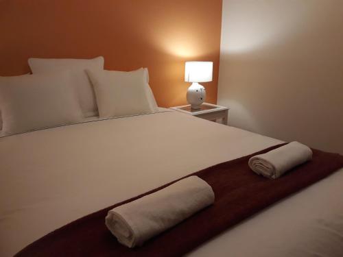 a bedroom with a large white bed with two towels on it at Stay @Airport in Lisbon