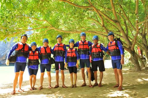 a group of people in life jackets standing under a tree at Carambola Bungalow in Phong Nha