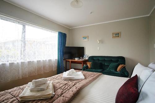 a bedroom with a bed and a chair and a window at Applaud BnB in Drury