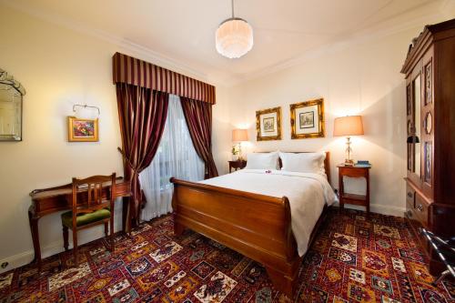 a bedroom with a bed and a table and a desk at Katoomba Manor in Katoomba
