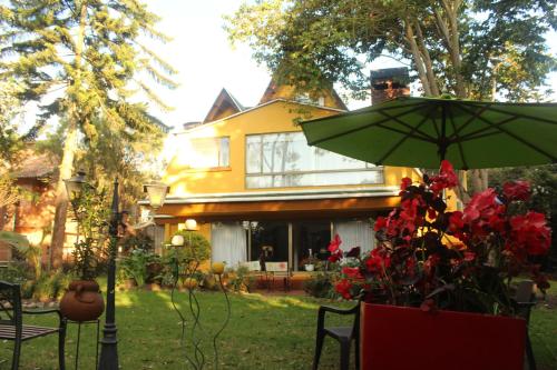 a house with a green umbrella in the yard at Casa Iris in Chía