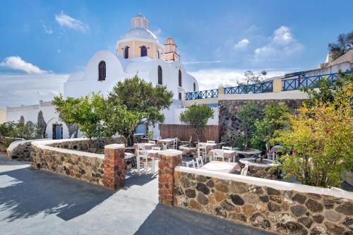 a church with a table and chairs in front of it at Anatoli Hotel & Spa in Fira