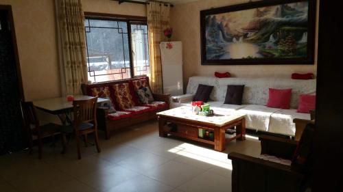 a living room with a couch and a table at Jumanyuan House in Miyun