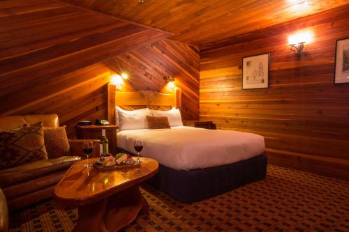 - une chambre avec un lit et un canapé dans l'établissement The Powderhorn Chateau, à Ohakune