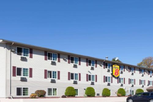 a large white building with red accents at Super 8 by Wyndham Johnstown/Gloversville in Johnstown
