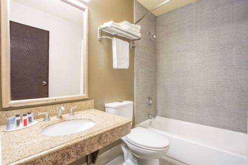 a bathroom with a sink and a toilet and a tub at Super 8 by Wyndham Waldorf in Waldorf