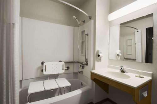 een badkamer met een wastafel, een bad en een spiegel bij Super 8 by Wyndham Port Angeles at Olympic National Park in Port Angeles