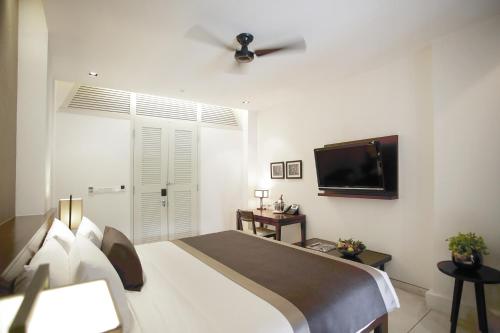 
a hotel room with a bed and a television at Amara Sanctuary Resort Sentosa (SG Clean, Staycation Approved) in Singapore

