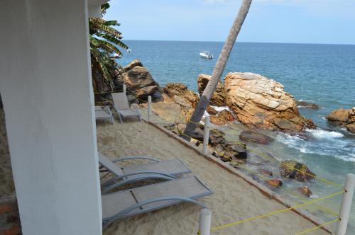 a group of lounge chairs on the beach at Casa Papaya in Yelapa