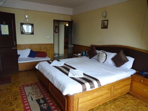 Posteľ alebo postele v izbe v ubytovaní Jain Group Hotel Royal Residency