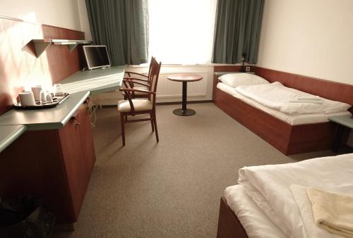 a hotel room with two beds and a desk at Kolej Akademie in Brno