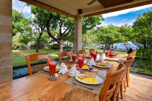 un tavolo in legno con cibo e bevande su un patio di Villa Semadhi a Pemuteran