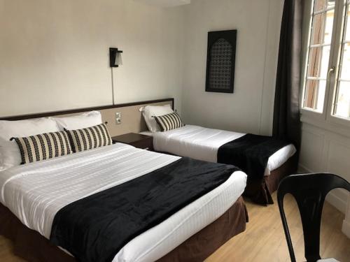 una camera d'albergo con due letti e una finestra di Les Initiés a Rouen