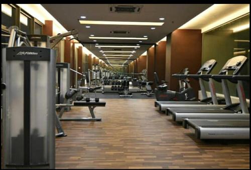 a gym with a row of treadmills and machines at Atlantis Residence Melaka in Melaka