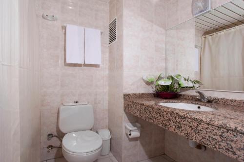 a bathroom with a toilet and a sink and a mirror at Kleopatra Aytur Apart Hotel in Alanya