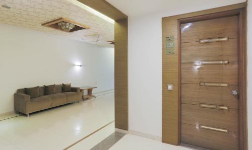 a living room with a couch and a wooden door at Hotel Apple Inn Vapi in Vapi