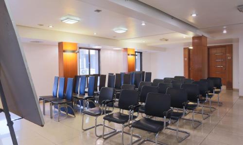 a room with rows of chairs in a room at Hotel Apple Inn Vapi in Vapi