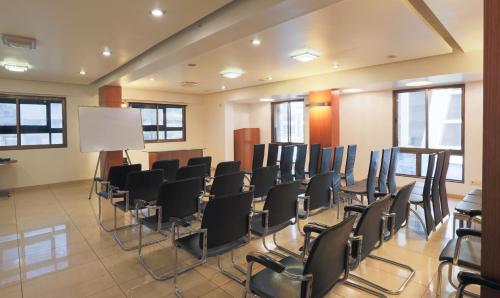 a conference room with black chairs and a podium at Hotel Apple Inn Vapi in Vapi