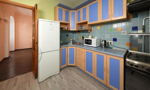 オムスクにあるпроспект Мира 66の青いタイルのキッチン(白い冷蔵庫付)